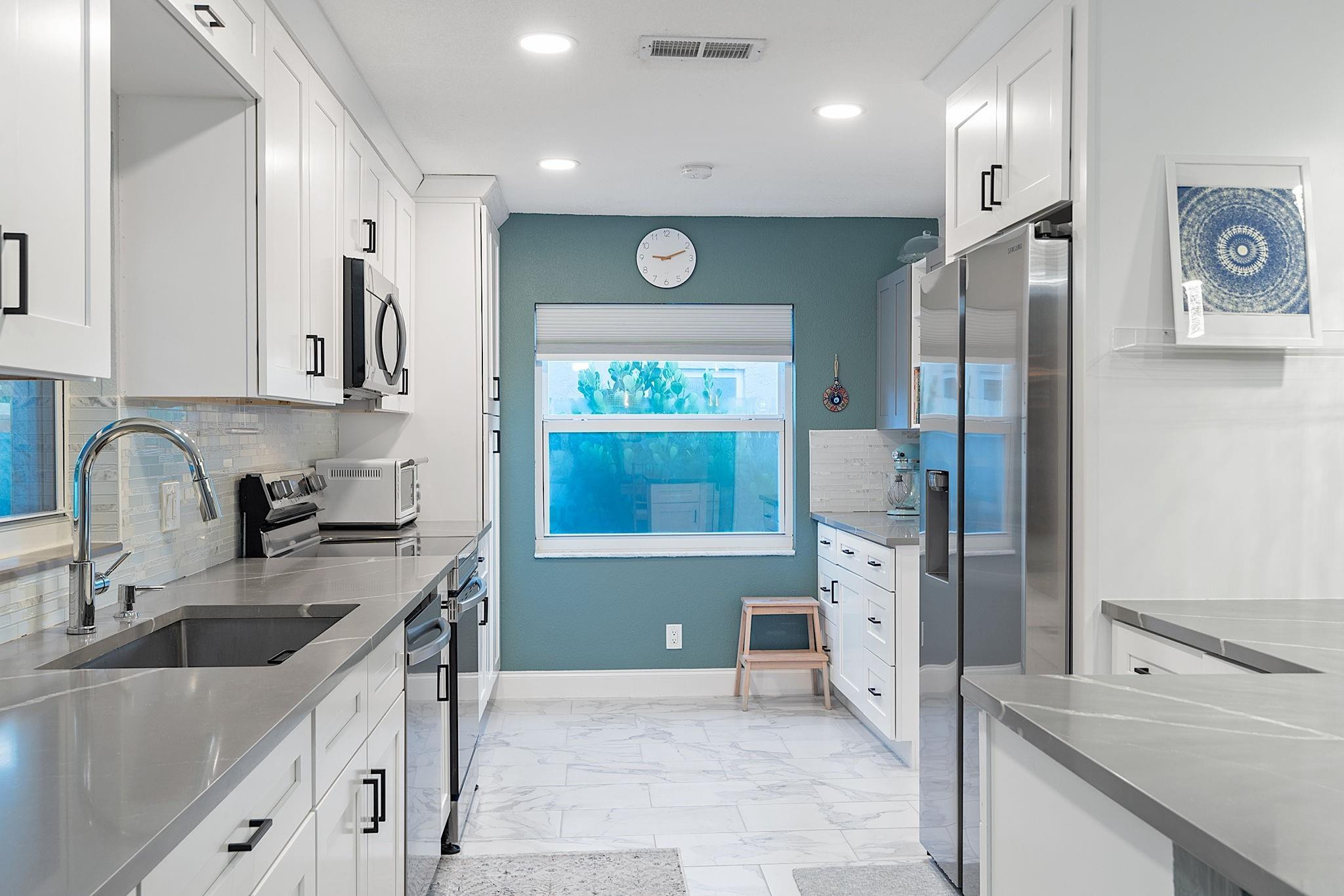 22848 Southwest 54th Way Boca Raton, FL 33433 - Photo 13 of 44 a kitchen with stainless steel appliances granite countertop a sink refrigerator and cabinets