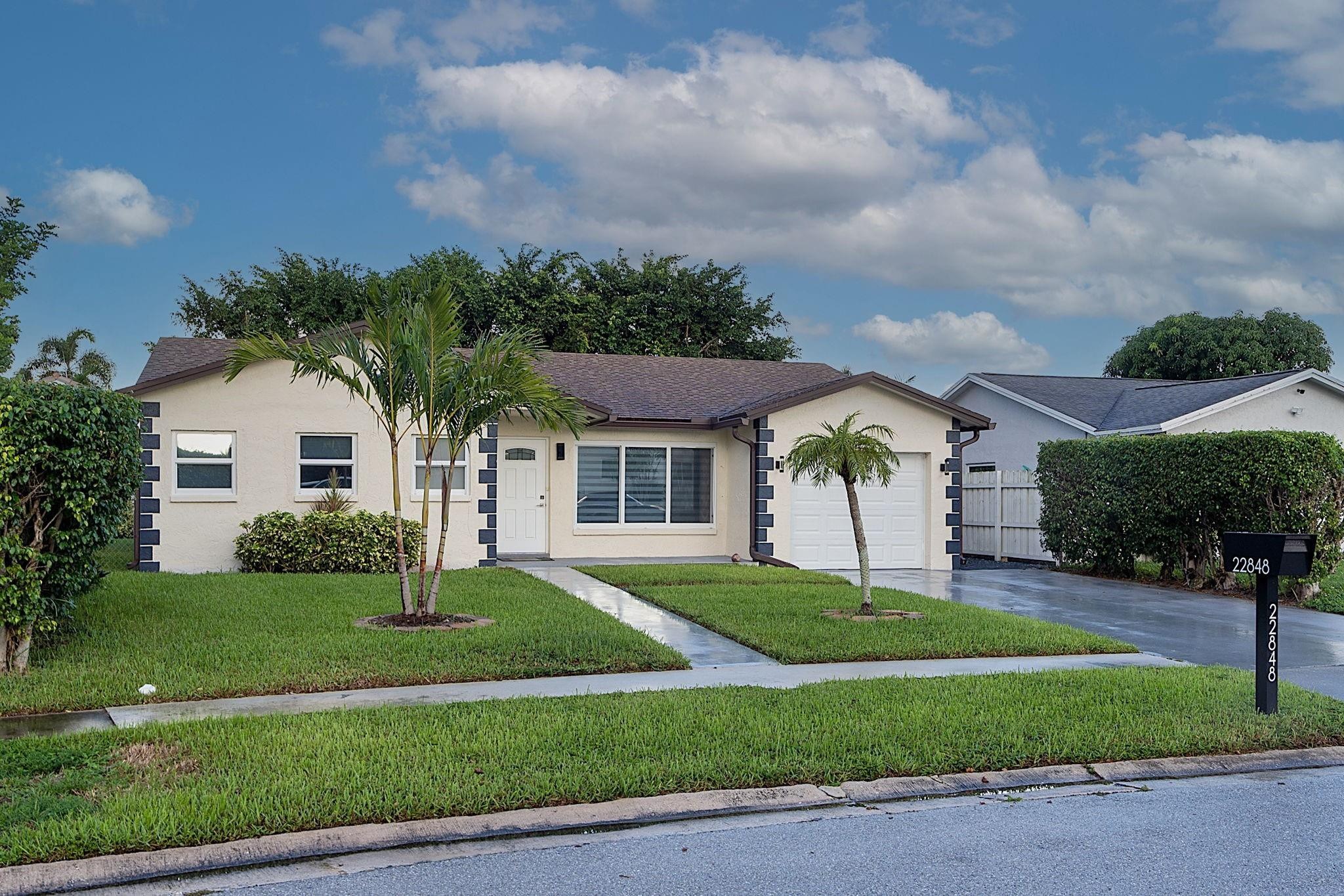 22848 Southwest 54th Way Boca Raton, FL 33433 - Photo 2 of 44 a front view of a house with a garden