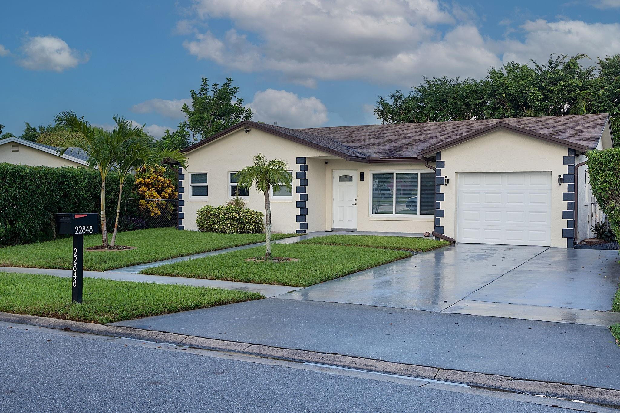 22848 Southwest 54th Way Boca Raton, FL 33433 - Photo 3 of 44 a front view of a house with a yard and garage