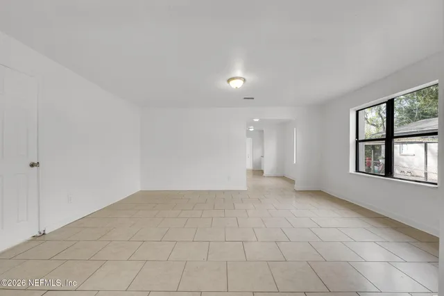 an empty room with windows and closet