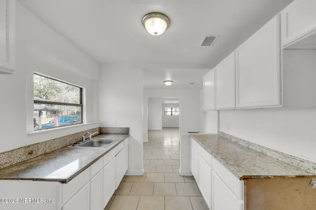 a large kitchen with granite countertop a sink and a stove