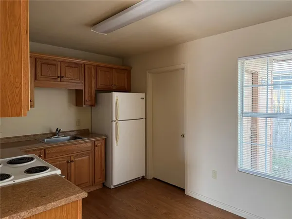 a kitchen with a refrigerator a stove a sink and a window