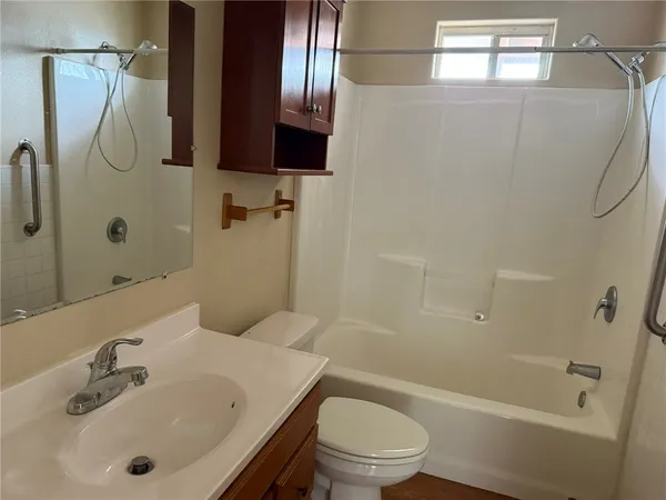 a bathroom with a sink a toilet and shower