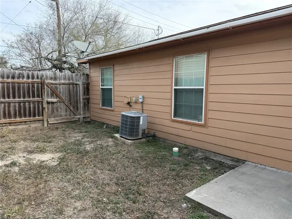 a view of a house with backyard and wooden fence