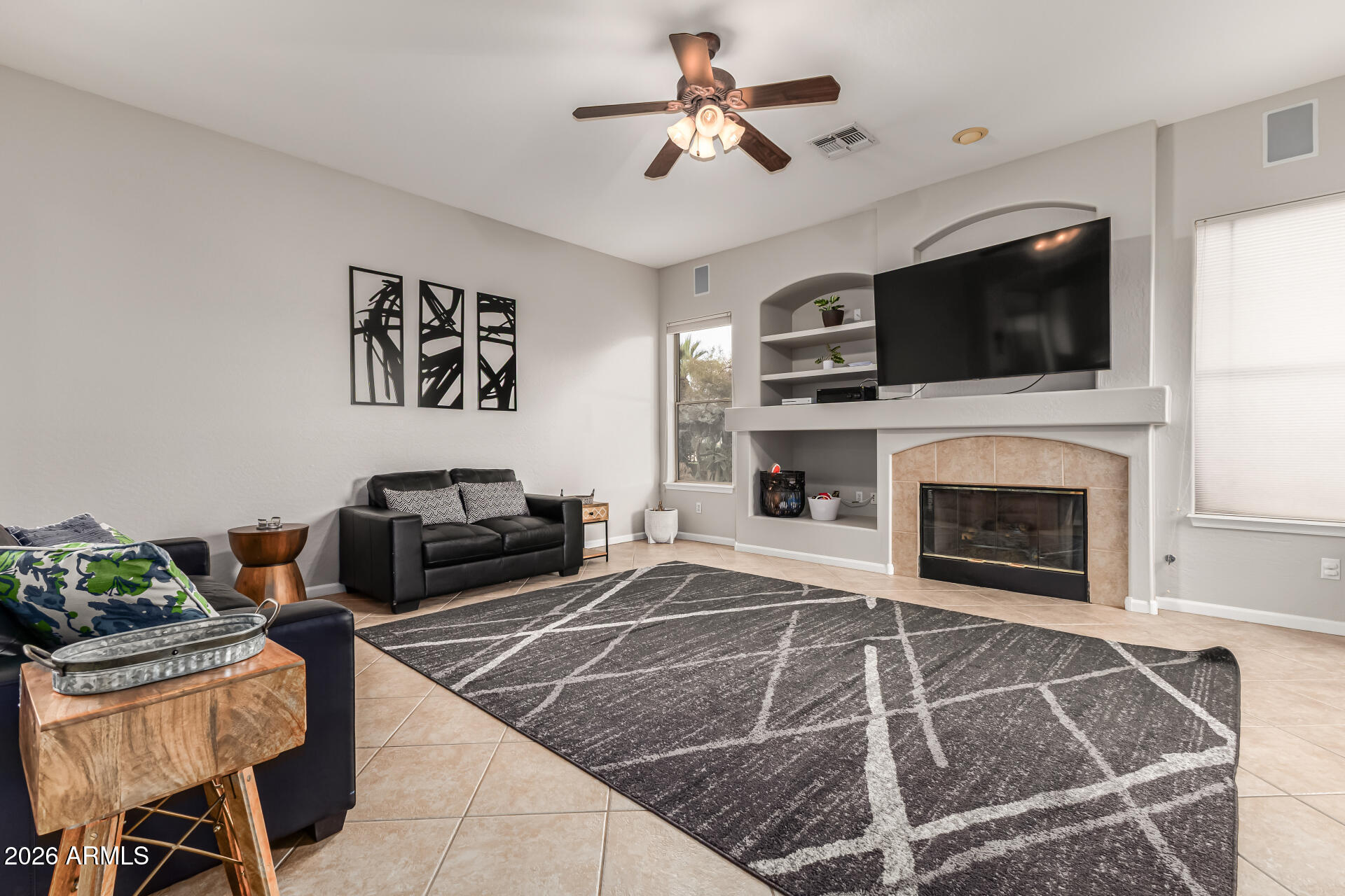13318 West Coronado Road Goodyear, AZ 85395 - Photo 13 of 48 a living room with furniture a flat screen tv and a fireplace