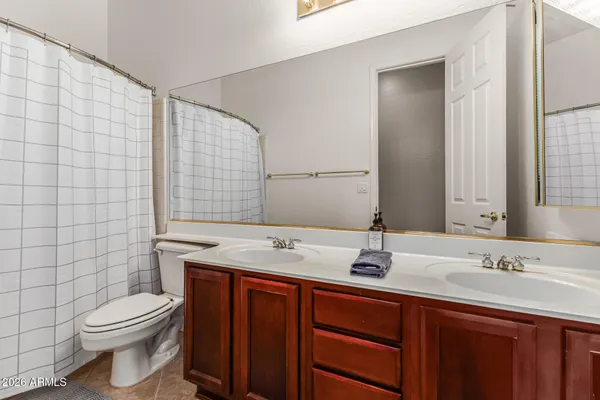 a bathroom with a granite countertop sink a toilet and mirror