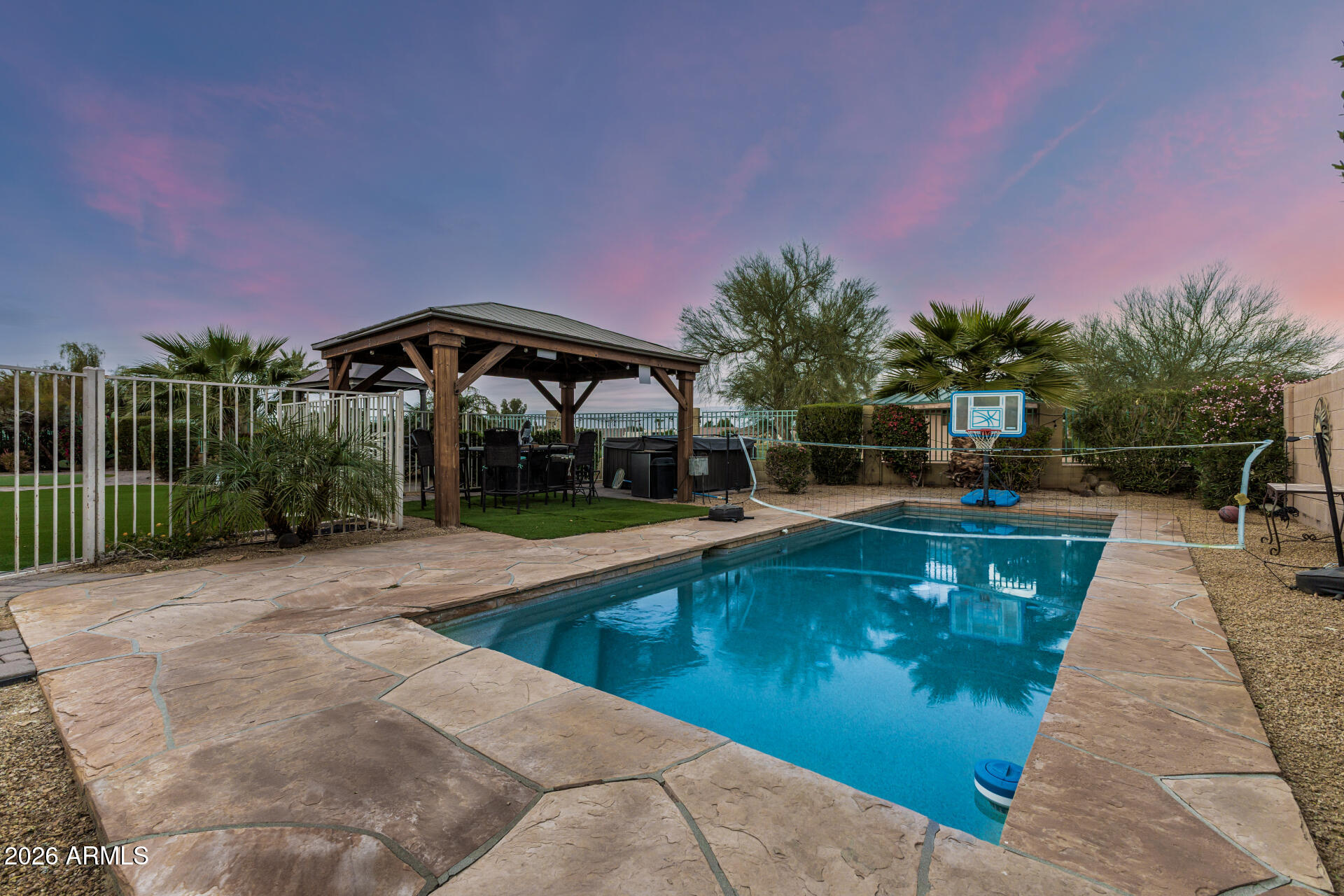 13318 West Coronado Road Goodyear, AZ 85395 - Photo 39 of 48 a view of a swimming pool with a table and chairs under an umbrella