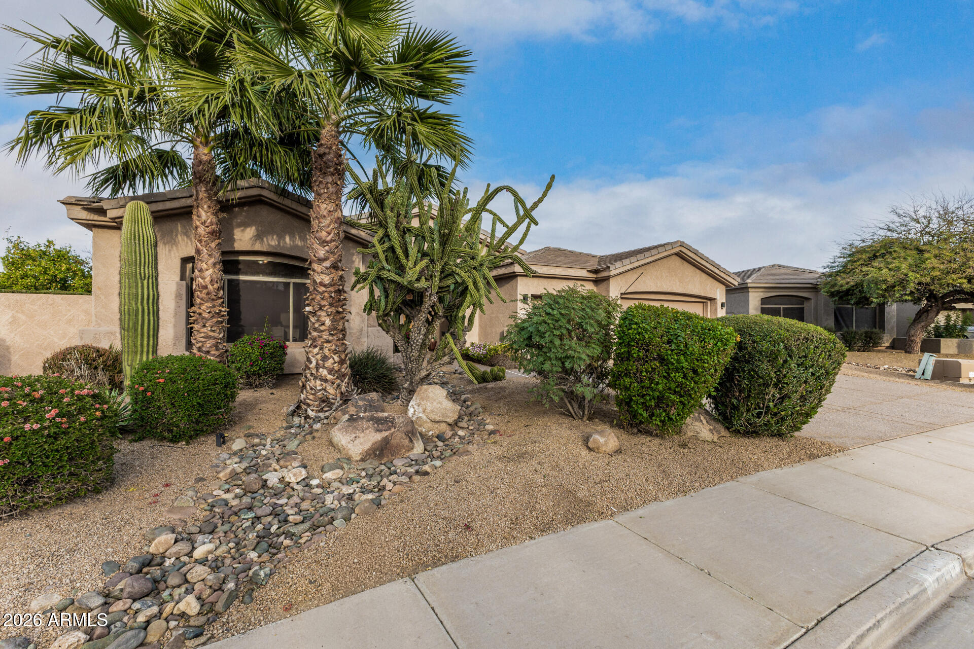 13318 West Coronado Road Goodyear, AZ 85395 - Photo 5 of 48 a front view of a house with a yard and potted plants