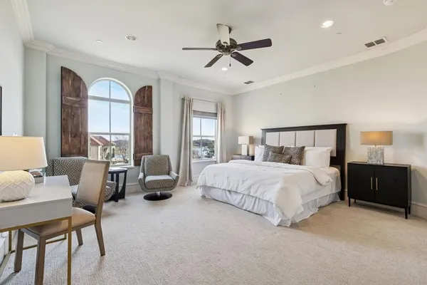 a bedroom with a large bed and a chandelier