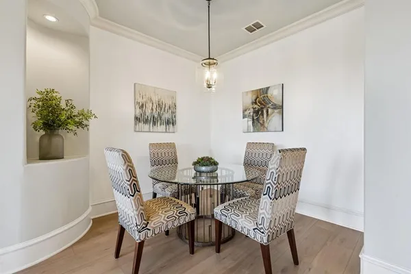 a dining room with furniture and potted plants