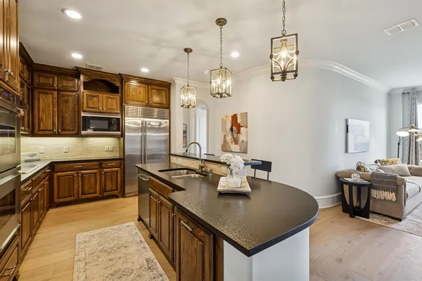 a kitchen with stainless steel appliances granite countertop a sink a stove and refrigerator