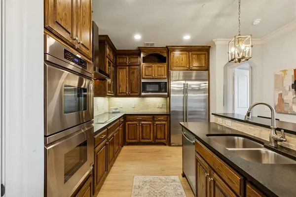 a kitchen with stainless steel appliances granite countertop a sink refrigerator and cabinets