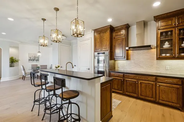 a kitchen with stainless steel appliances granite countertop wooden cabinets and a refrigerator