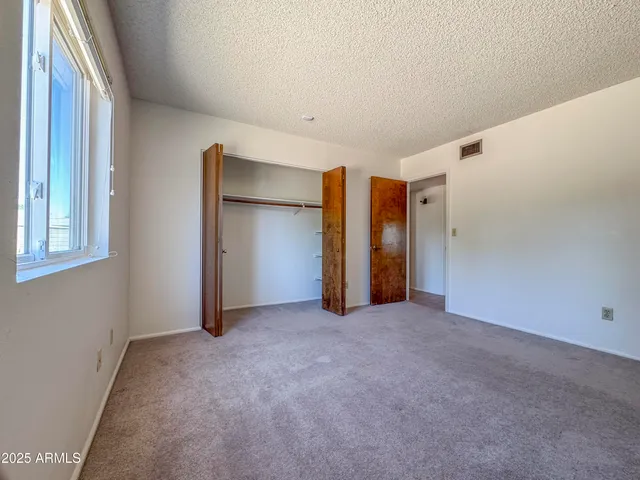 a view of a big room with windows and chandelier fan