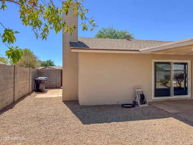 a porch with a table and chairs under an umbrella