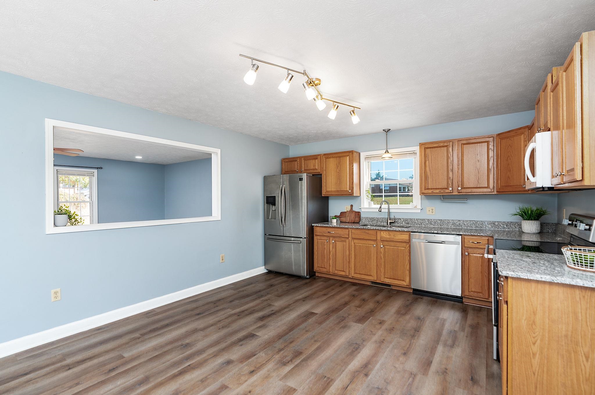 812 New Hope Road Staunton, VA 24401 - Photo 16 of 67 a kitchen with stainless steel appliances granite countertop a refrigerator a stove top oven a sink dishwasher and wooden floor