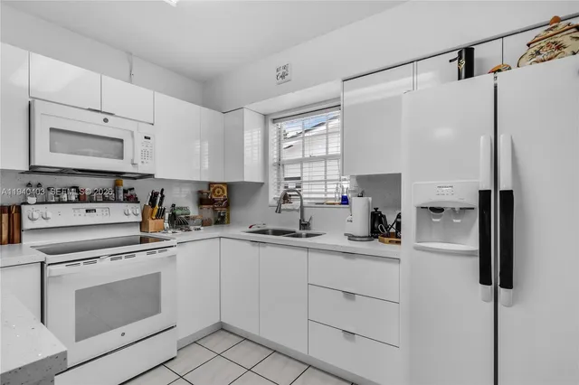 a kitchen with white cabinets and white appliances