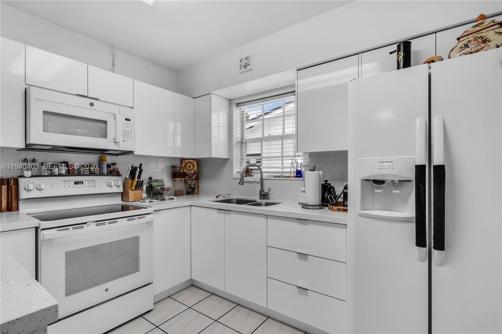 2145 Southwest 26th Street Miami, FL 33133 - Photo 8 of 26 a kitchen with white cabinets and white appliances