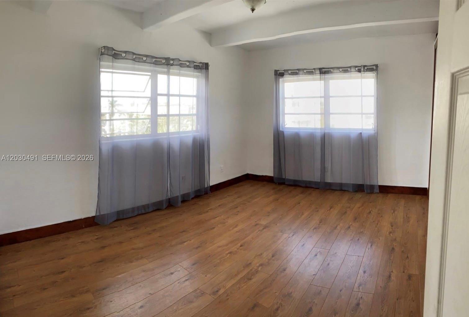 7410 Southwest 82nd Street, Unit K401 Miami, FL 33143 - Photo 3 of 5 an empty room with wooden floor and windows
