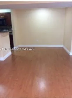 a view of a room with wooden floor and fan