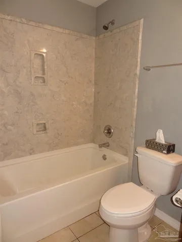 a white toilet and tub sitting next to a bathroom sink
