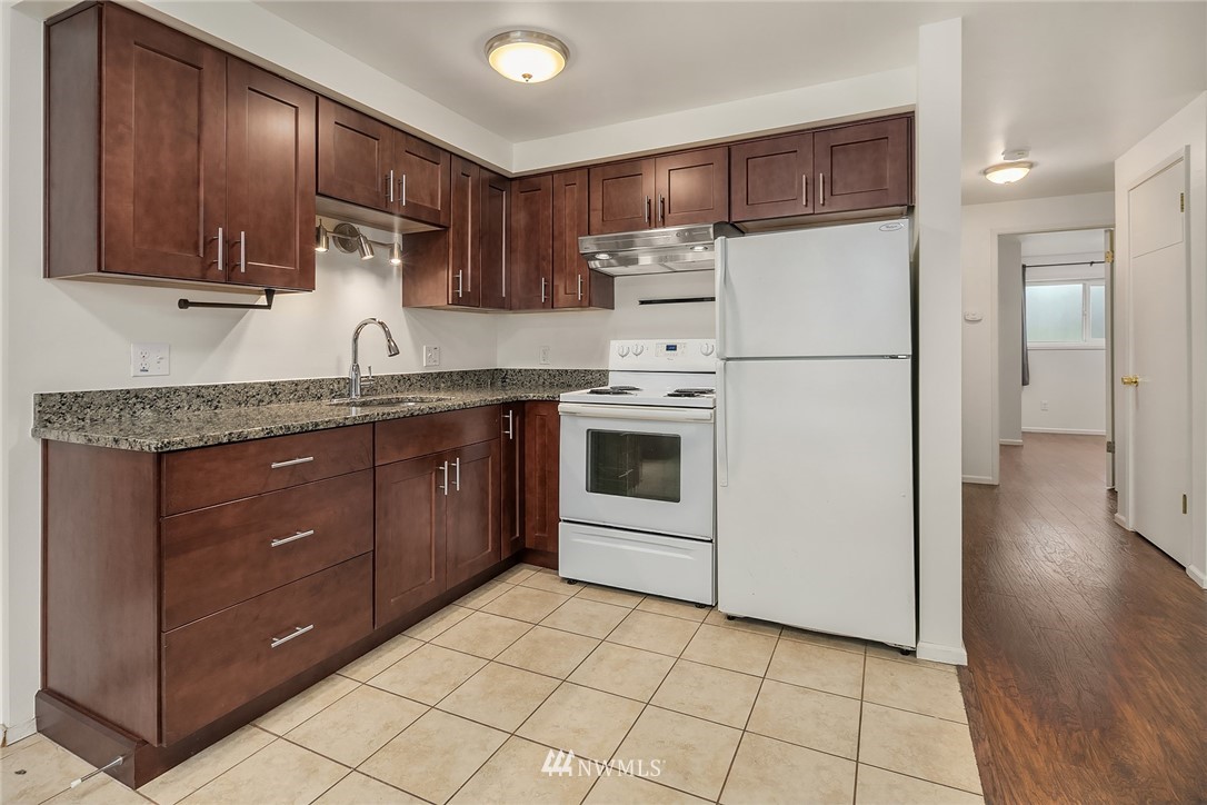 946 North 89th Street Seattle, WA 98103 - Photo 5 of 16 a kitchen with a sink a stove and cabinets