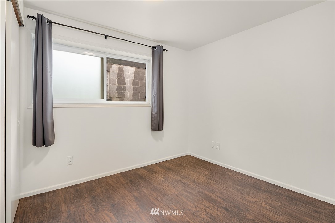 946 North 89th Street Seattle, WA 98103 - Photo 9 of 16 a view of an empty room with wooden floor and windows