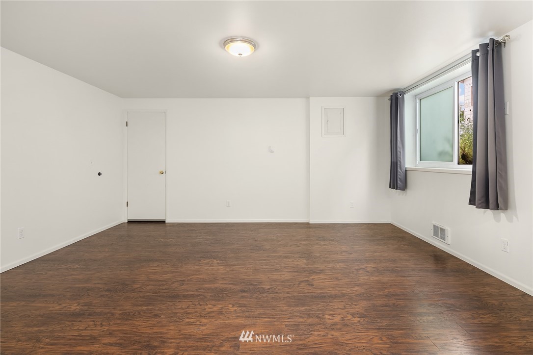 946 North 89th Street Seattle, WA 98103 - Photo 10 of 16 a view of an empty room with wooden floor and a window