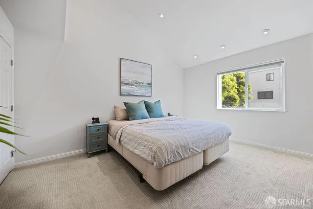 a bedroom with a bed and painting on the wall