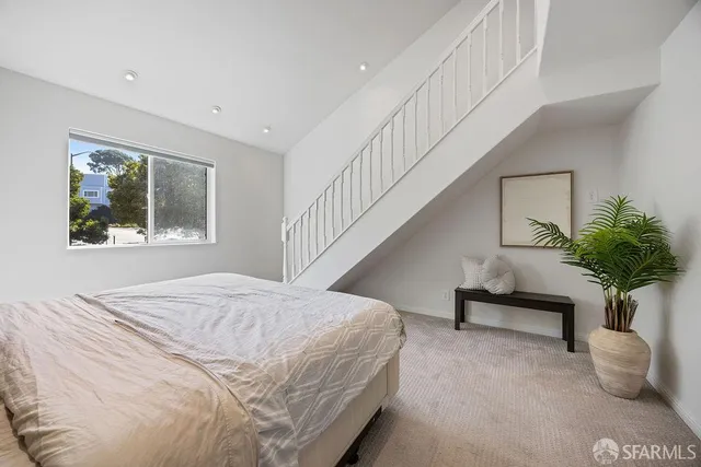 a bedroom with a bed and a potted plant
