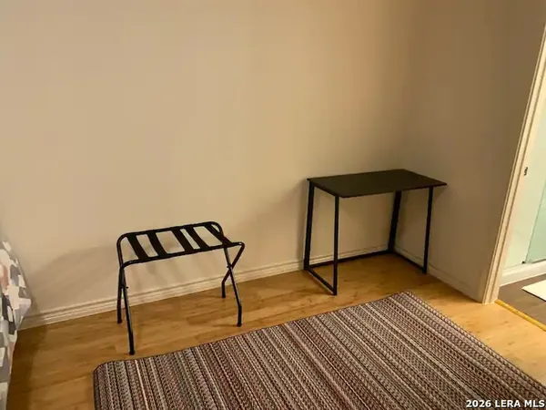 a bed sitting in a bedroom next to a cabinet and a chandelier