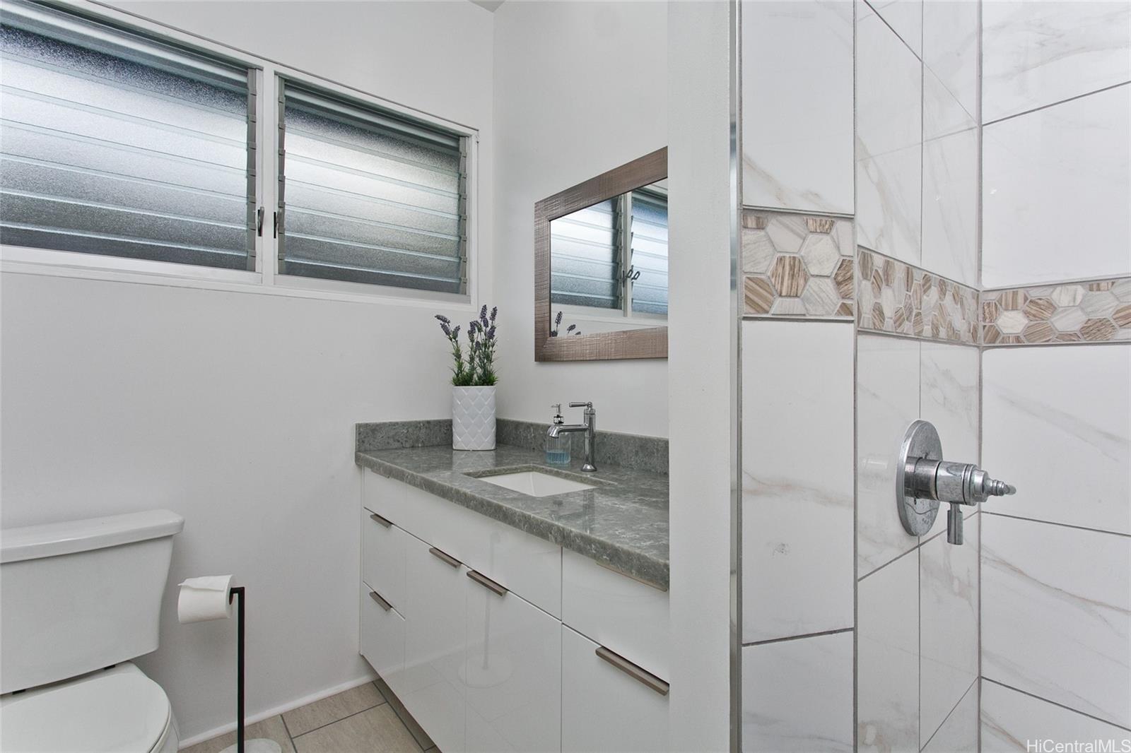3233 Pacific Heights Road Honolulu, HI 96813 - Photo 13 of 25 a bathroom with a granite countertop toilet sink and mirror