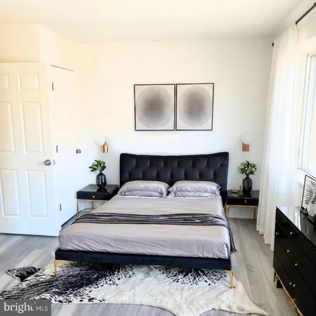 a bedroom with a large bed and wooden floor