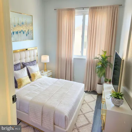 a bedroom with a bed lamp and a large window