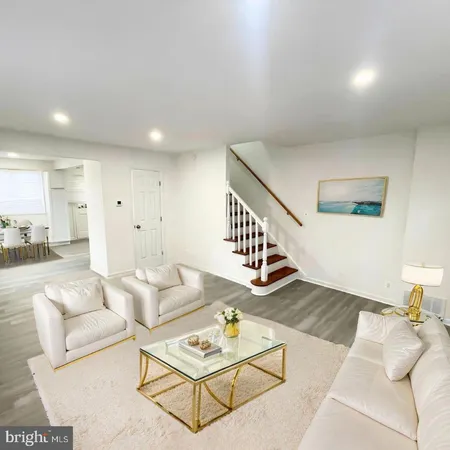 a living room with furniture and view of kitchen