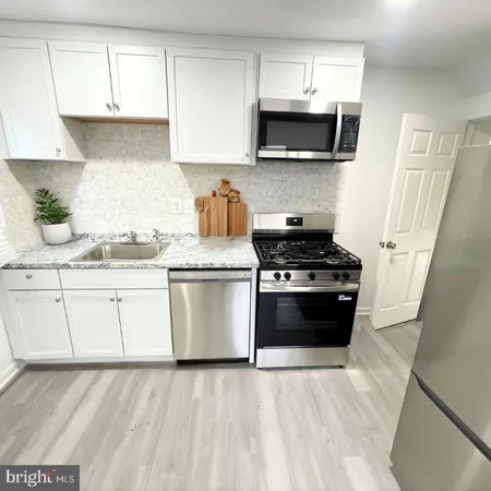 a kitchen with stainless steel appliances a stove a microwave a sink and cabinets