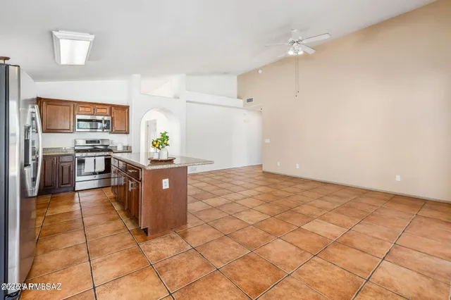 a kitchen with stainless steel appliances cabinets and front door