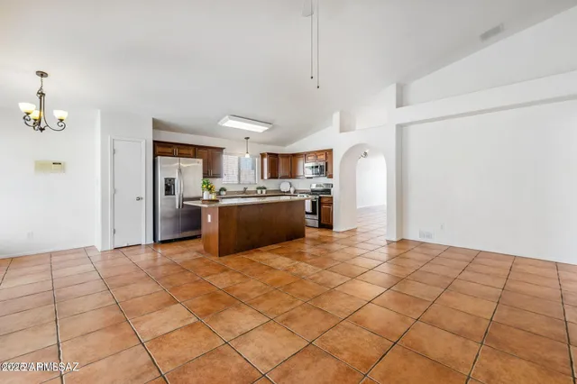 a kitchen with stainless steel appliances granite countertop a refrigerator and a stove top oven