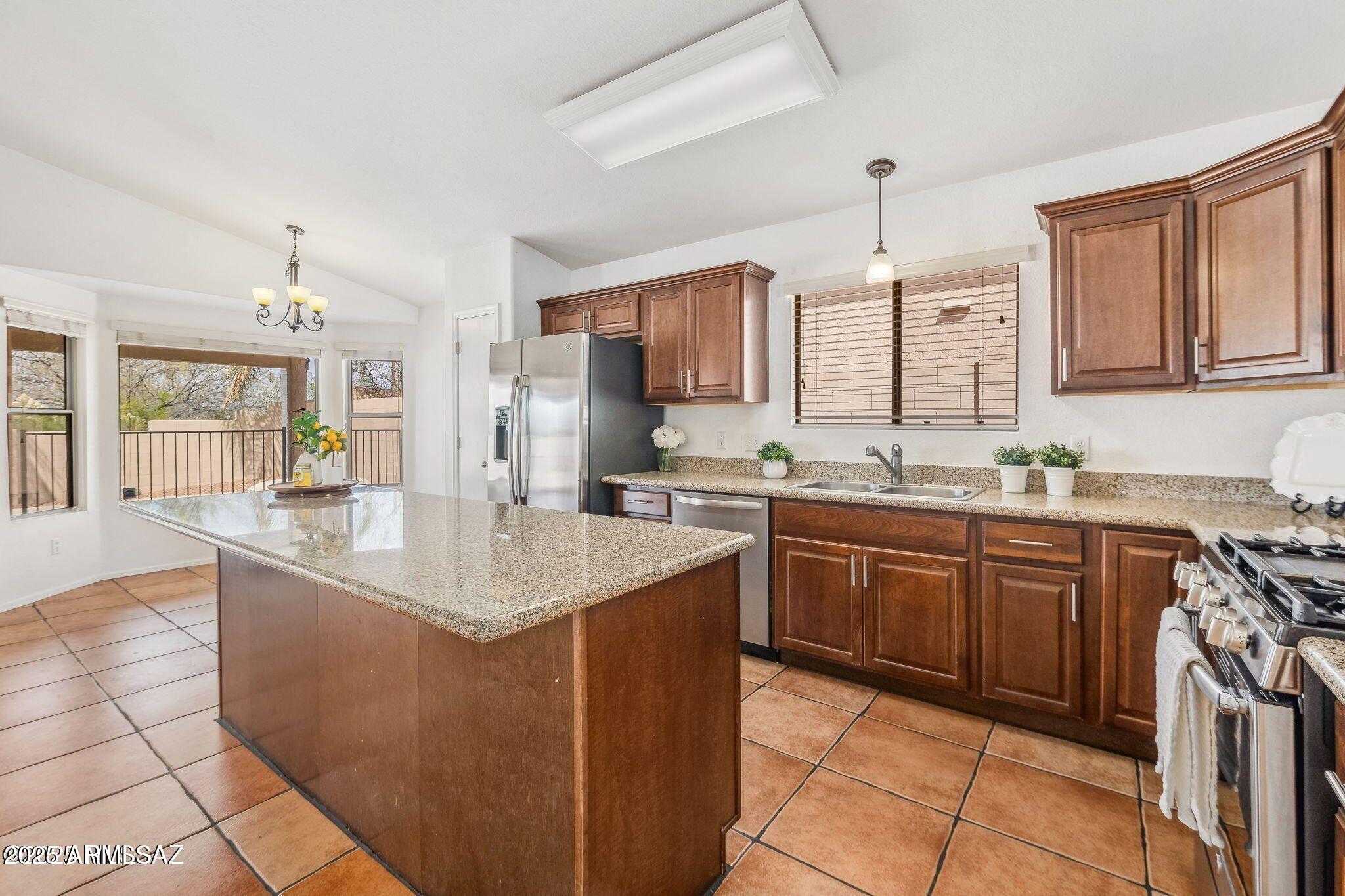 11161 North Par Drive Oro Valley, AZ 85737 - Photo 10 of 35 a kitchen with kitchen island granite countertop a sink counter top space appliances and cabinets