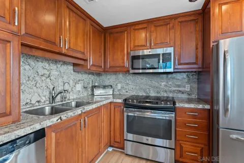 a kitchen with granite countertop wooden cabinets and a stove top oven