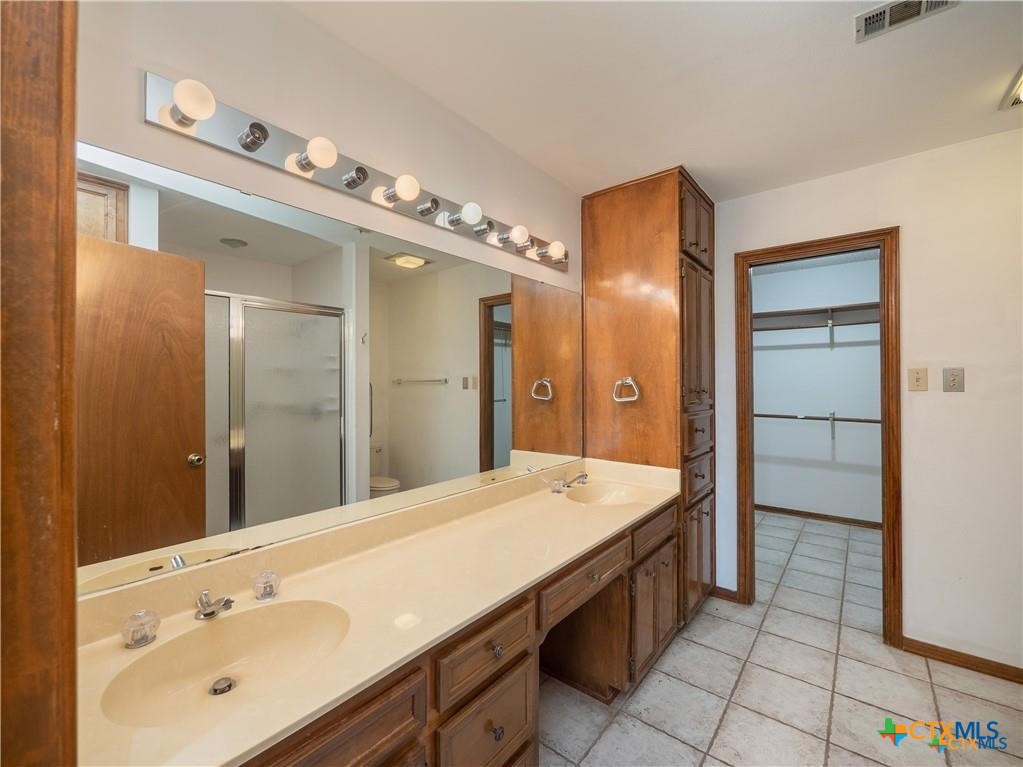 3901 Chisholm Trail, Unit 12 Salado, TX 76571 - Photo 7 of 9 a spacious bathroom with a granite countertop sink mirror and shower