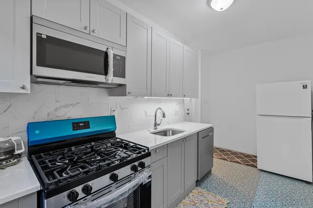 a kitchen with stainless steel appliances a stove a microwave and sink