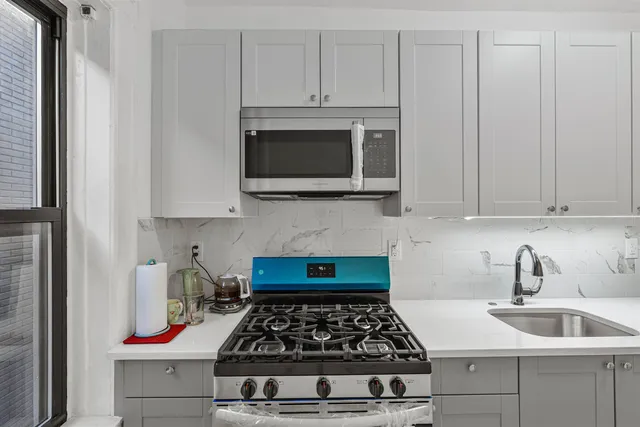 a kitchen with white cabinets and appliances