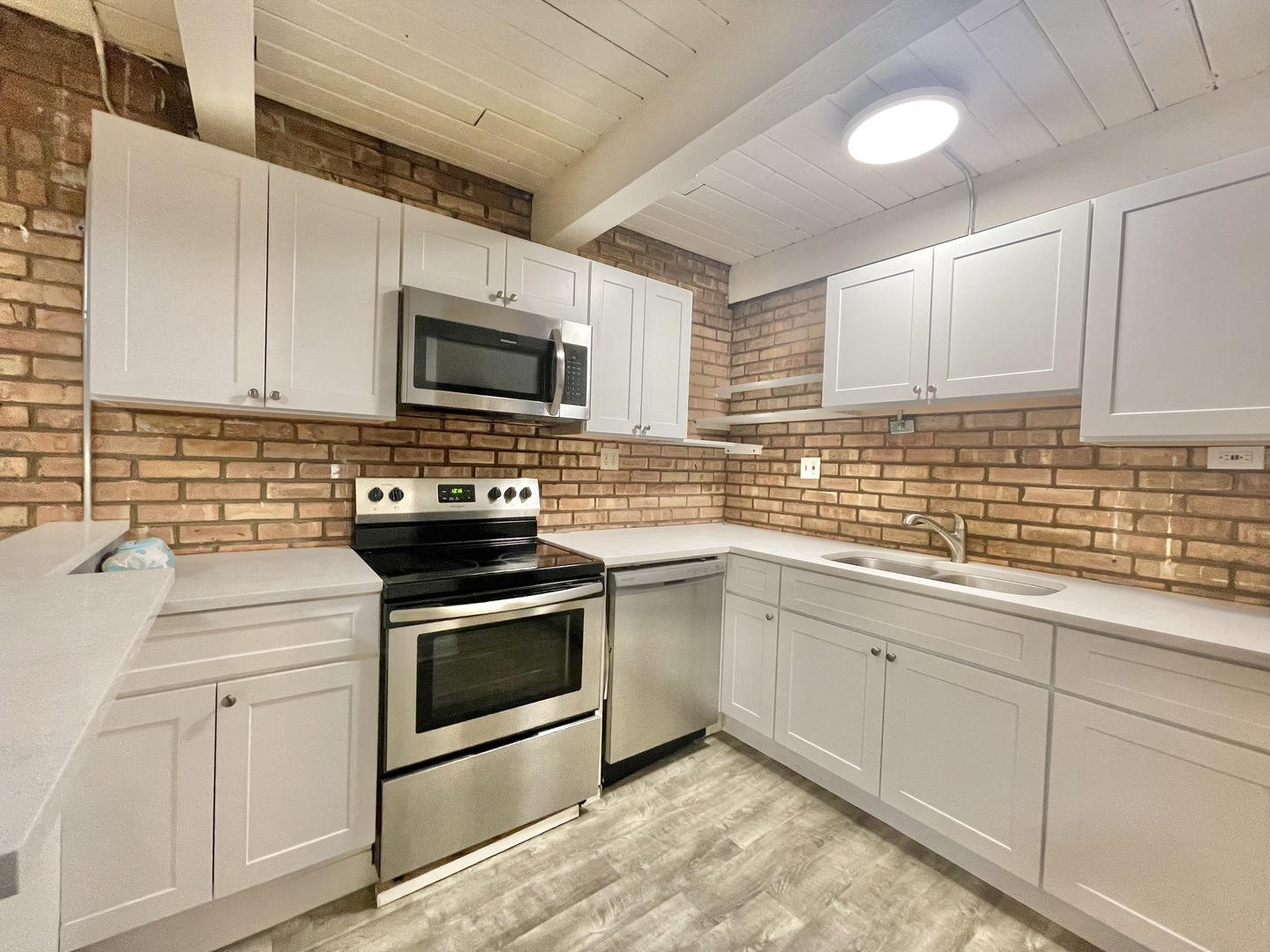 806 South Loomis Street, Unit B Chicago, IL 60607 - Photo 4 of 17 a kitchen with white cabinets stainless steel appliances and sink