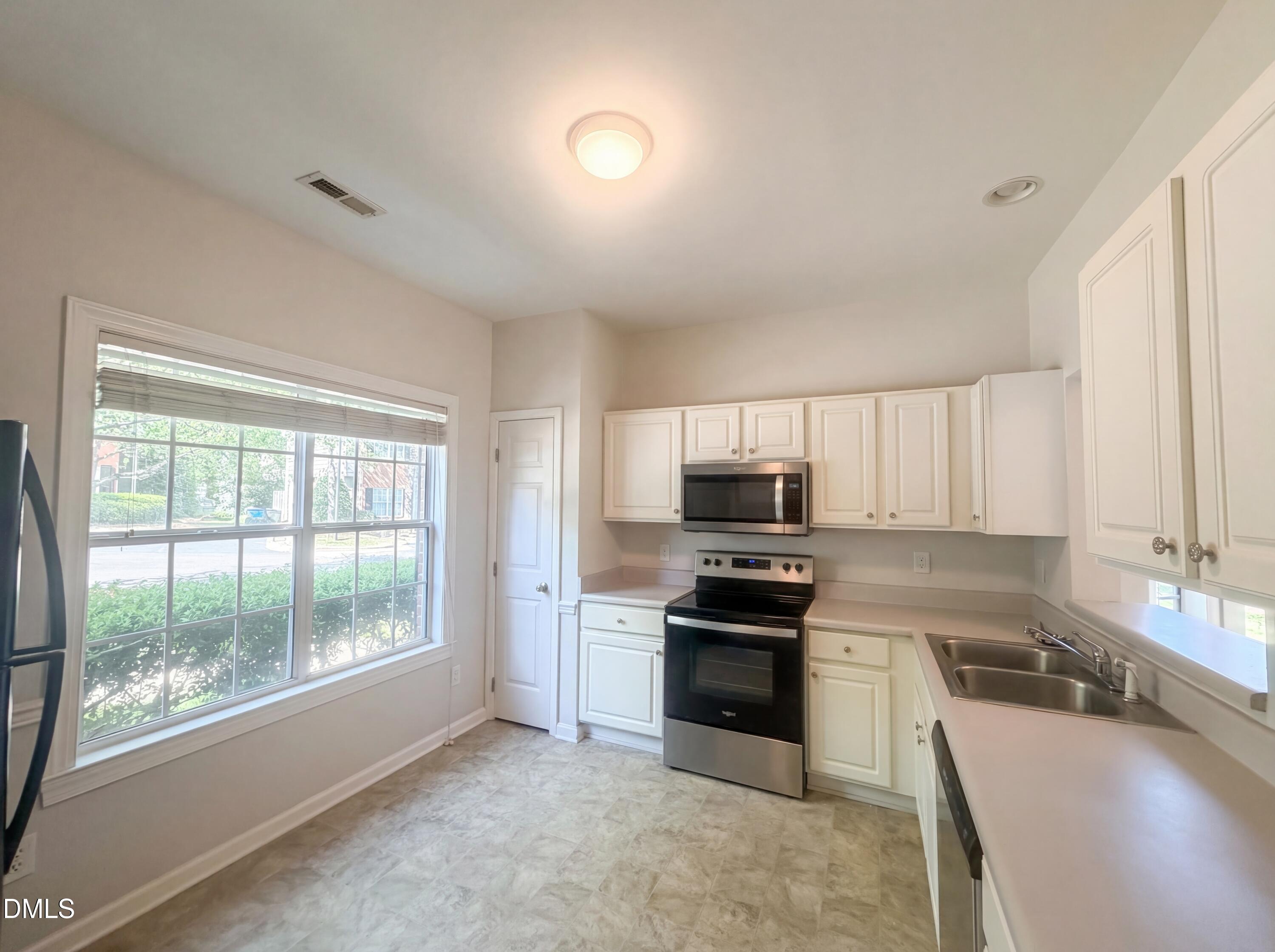 4321 Pine Springs Court Raleigh, NC 27613 - Photo 2 of 15 a kitchen with stainless steel appliances a stove sink and cabinets