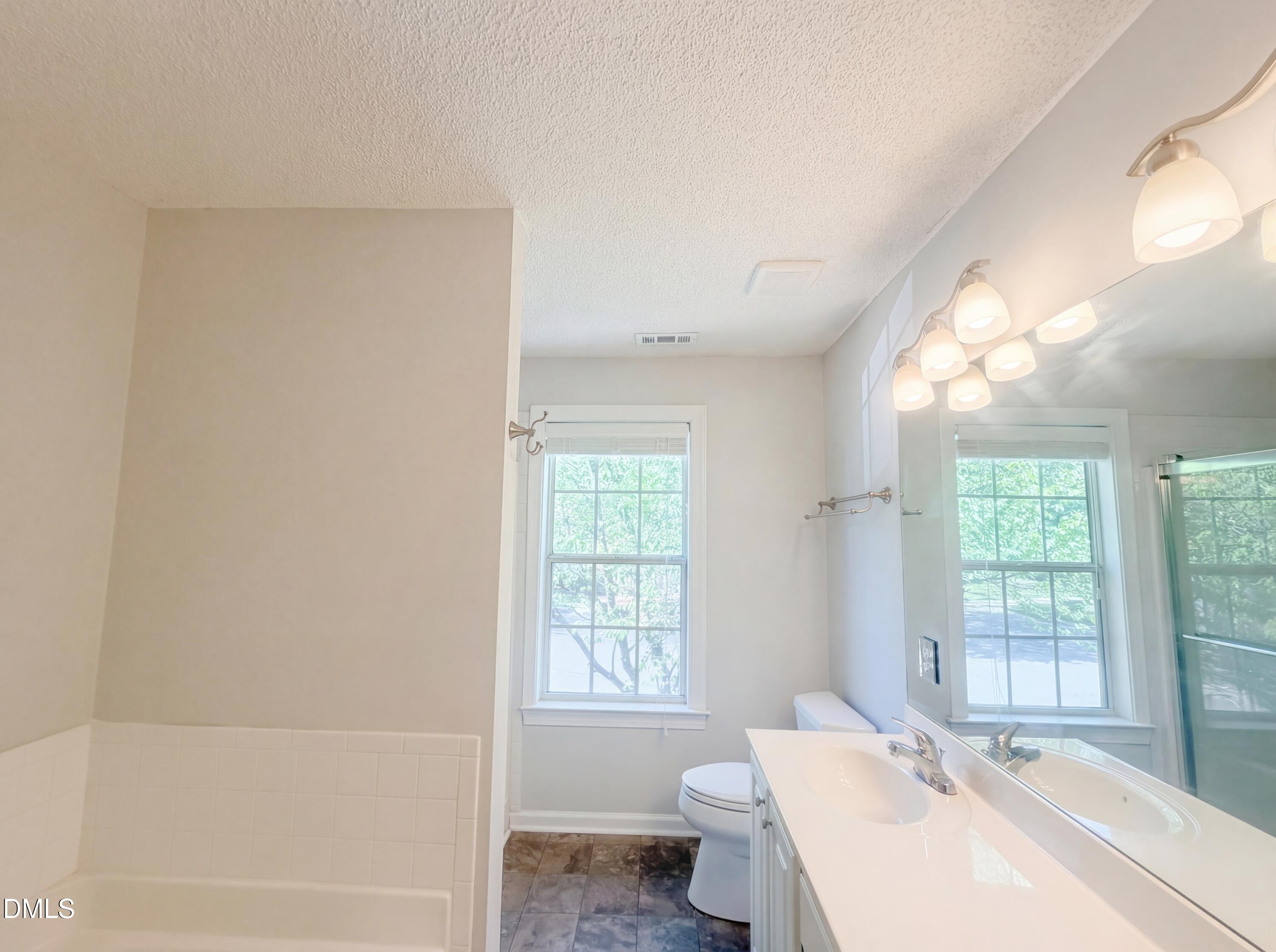 4321 Pine Springs Court Raleigh, NC 27613 - Photo 6 of 15 a bathroom with a bathtub sink vanity mirror and toilet