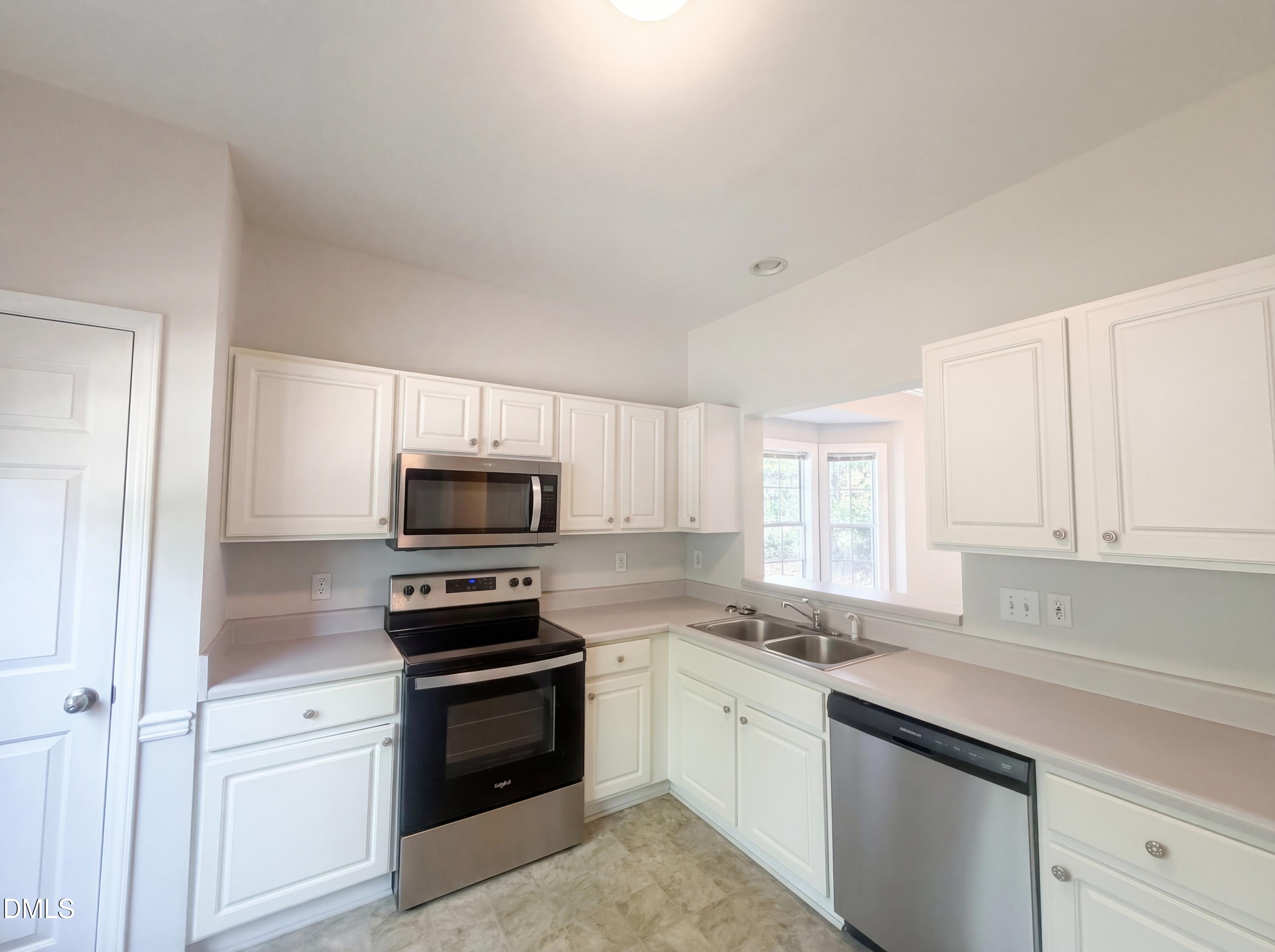4321 Pine Springs Court Raleigh, NC 27613 - Photo 10 of 15 a kitchen with granite countertop a stove microwave and sink