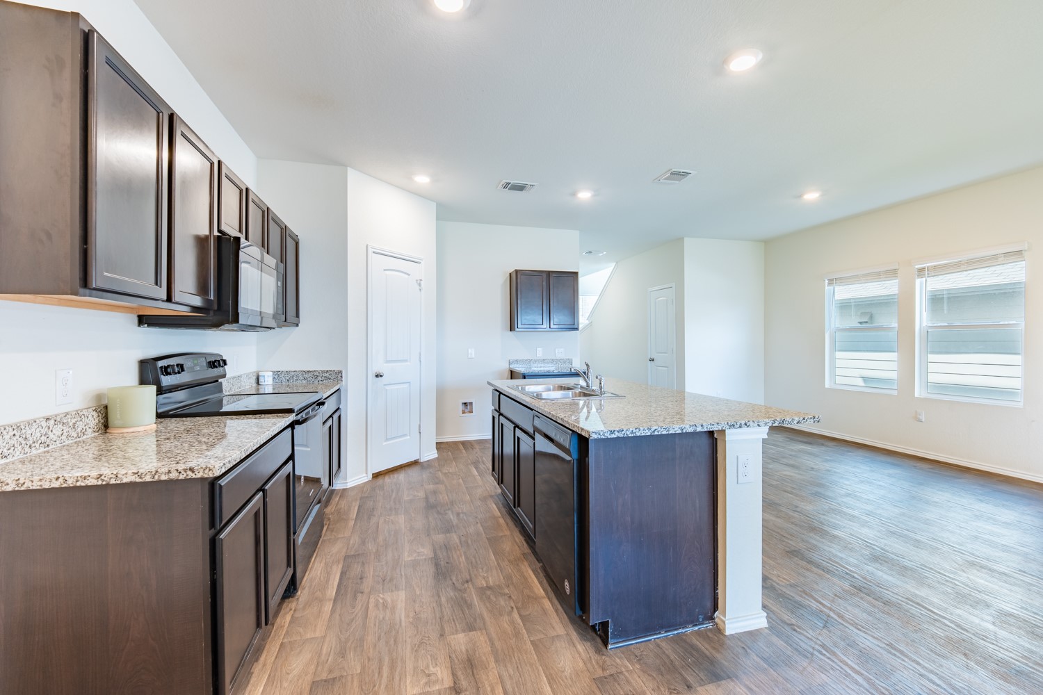 14917 Bajada Rd Manor Manor, TX 78653 - Photo 13 of 31 Kitchen featuring dark wood-finish cabinetry, granite countertops, and stainless steel appliances