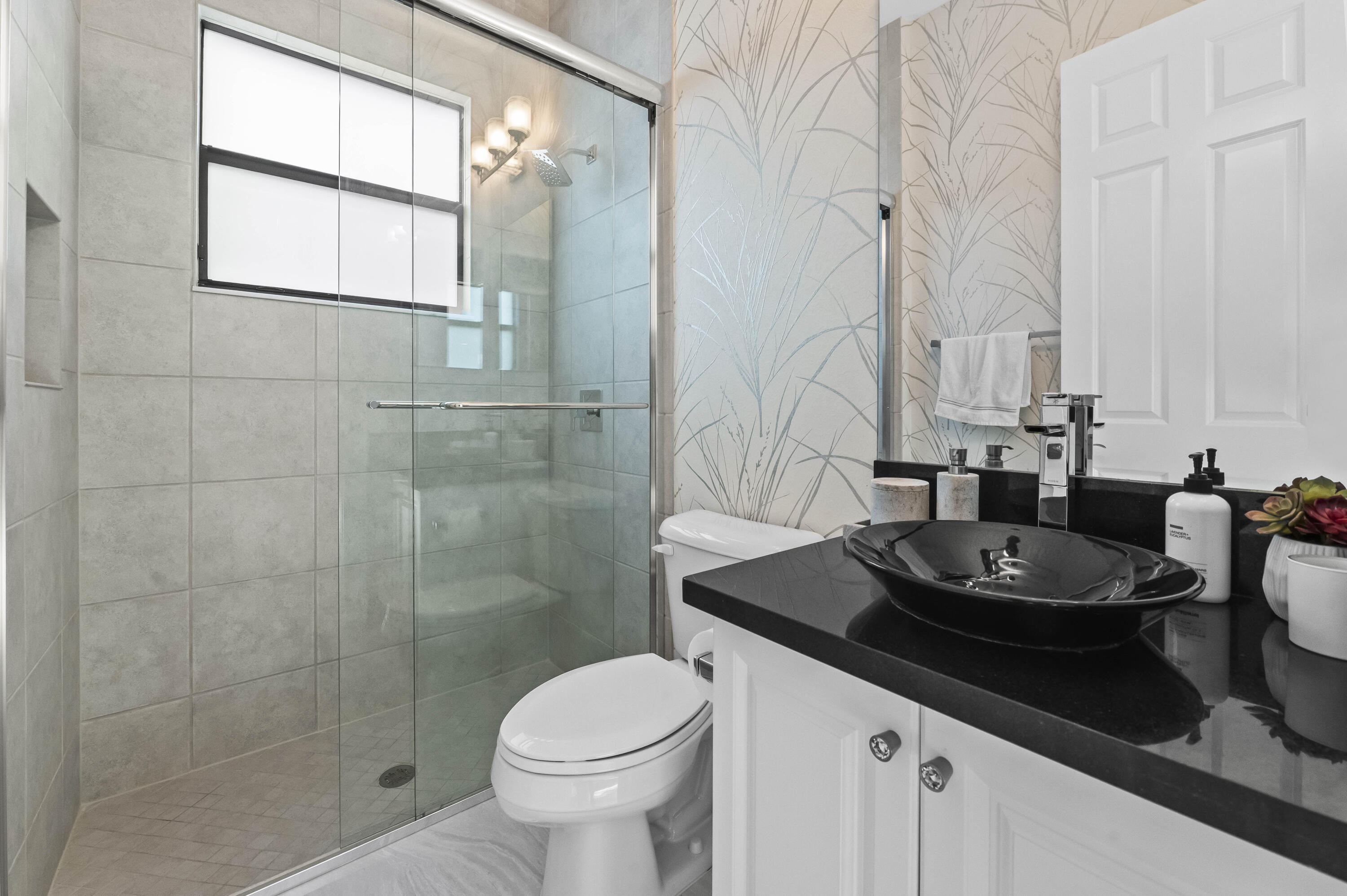 9795 Rennes Lane Delray Beach, FL 33446 - Photo 22 of 79 a bathroom with a granite countertop sink a toilet and a mirror