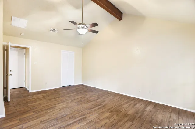 a view of empty room with wooden floor
